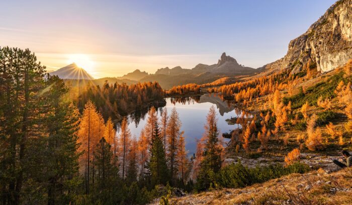 Podzimní východ slunce nad jezerem Lago Federa se zlatými modříny